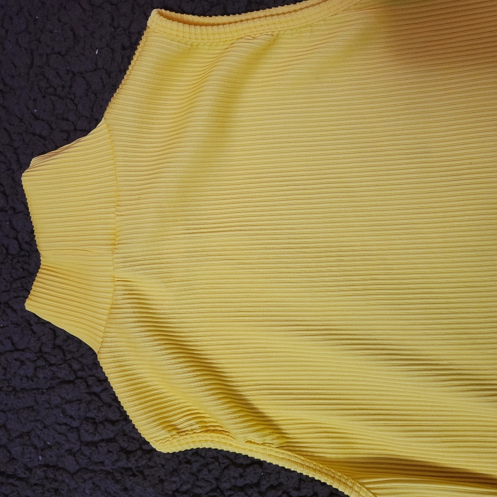 Yellow colour sleeveless turtleneck top.